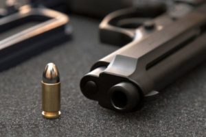 A gun in Rhode Island with five bullets symbolizing gun crime.